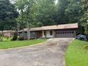 Ranch style home with a large front yard, mature trees, and an attached two car garage at 4325 Dawning Ln, Douglasville, GA 30135