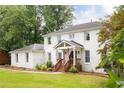 Beautifully updated white brick home showcasing a cozy front porch with wooden stairs and an American flag at 5070 Hensley Dr, Atlanta, GA 30338