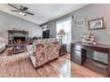 Comfortable living room featuring hardwood floors, a fireplace, neutral paint, and a ceiling fan at 629 Silver Trace Ct, Woodstock, GA 30189