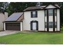 Two-story home shows solar panels and a two-car garage with a traditional suburban aesthetic at 3255 Hunters Crossing Pt, Lithonia, GA 30038