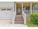 Inviting front porch with brick steps and columns, with a view of the garage and a neatly trimmed lawn at 3541 Wilton Ave, Atlanta, GA 30340