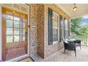 Charming front porch featuring brick detail, a cozy seating area, and a welcoming entryway with a wooden door at 3541 Wilton Ave, Atlanta, GA 30340