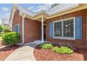 Close-up of a brick home showcasing the entryway with blue shutters and landscaped details at 2905 Ivey Ridge Ln, Roswell, GA 30076