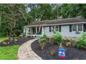 Landscaped front yard with mulch beds, flowers, and a walkway leading to the charming home at 3861 Riding Sw Trl, Powder Springs, GA 30127