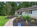 View of the home with a winding stone pathway and well-maintained landscaping at 3861 Riding Sw Trl, Powder Springs, GA 30127