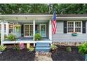 Inviting front porch with swing, rocking chair, and patriotic decor creates a warm welcome at 3861 Riding Sw Trl, Powder Springs, GA 30127