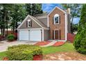 Exterior view of a two-story house with a two-car garage, showcasing the well-maintained lawn and brick accents at 914 Wenham Ln, Lawrenceville, GA 30044