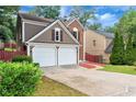 View of the front exterior featuring a driveway and attached two-car garage, showcasing the home's architectural details at 914 Wenham Ln, Lawrenceville, GA 30044