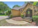 Home's entrance features a stone facade and a dark wood door framed by green bushes, for warm curb appeal at 110 Boulder Dr, Roswell, GA 30075