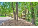 Charming yellow home nestled amongst lush green trees, offering a sense of seclusion and natural beauty at 110 Boulder Dr, Roswell, GA 30075