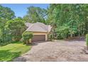 Traditional home boasts mature trees, a stone accent wall, and a two-car garage, all adding to its charm at 110 Boulder Dr, Roswell, GA 30075
