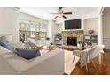 Bright living room features a stone fireplace, ceiling fan, and hardwood floors at 1935 Cobblestone Ne Cir, Brookhaven, GA 30319