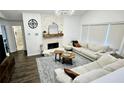 Cozy living room featuring a decorative fireplace, hardwood floors and natural light from the large window at 1338 Barrett Bluff Dr, Lawrenceville, GA 30045