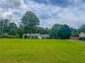 Exterior view of a home with a spacious front yard and mature trees creating a private setting at 4017 S South Bogan Road Rd, Buford, GA 30519