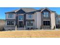 Elegant two-story home with a stone facade, covered entryway, and a well-manicured lawn at 3063 Reserve Ct Sw, Conyers, GA 30094