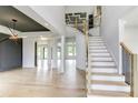 Bright, open foyer with staircase, hardwood floors, and modern lighting fixtures at 3063 Reserve Ct Sw, Conyers, GA 30094