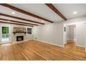 Spacious living room with hardwood floors, exposed beam ceiling, and cozy brick fireplace at 229 Devonwood Dr, Atlanta, GA 30328