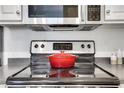 Close-up of the kitchen stove with stainless steel microwave and grey countertops at 1101 Juniper Ne St # 619, Atlanta, GA 30309