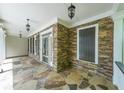 Inviting covered porch with stone flooring and stacked stone columns create a cozy outdoor space at 1403 Benbrooke Circle Northwest Nw Cir, Acworth, GA 30101