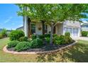 Lush landscaped front yard with a charming brick home in the background at 4265 Pleasant Woods Dr, Cumming, GA 30028
