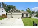 Inviting one-story home with a well-kept lawn, a two-car garage, and a welcoming entrance, showcasing suburban charm at 122 Riverbirch Way, Dallas, GA 30157