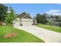 Beautiful one-story home with a well-manicured lawn and a long driveway leading to a spacious two-car garage at 122 Riverbirch Way, Dallas, GA 30157