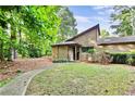 Inviting exterior with wood siding, stone accents, lush greenery, and a pathway leading to the entrance at 830 Bonnie Glen Se Dr, Marietta, GA 30067