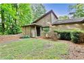 Attractive exterior showcasing wood siding, stone details, and a well-kept lawn with mature trees at 830 Bonnie Glen Se Dr, Marietta, GA 30067