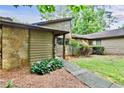 Cozy home with a stone facade, wood siding, manicured landscaping, and a welcoming walkway at 830 Bonnie Glen Se Dr, Marietta, GA 30067