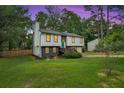 Inviting home with a spacious front yard, manicured lawn, and a quaint deck, perfect for outdoor enjoyment and relaxation at 230 Sheringham Dr, Roswell, GA 30076