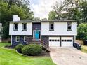 Beautiful home featuring a well-maintained front yard, a deck, and a two-car garage, offering both curb appeal and practicality at 230 Sheringham Dr, Roswell, GA 30076