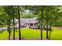 Scenic view of a well-maintained home with lush greenery, visible through a screen of mature trees at 7269 Tyree Rd, Winston, GA 30187