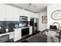 Well-lit kitchen with white cabinets, stainless steel appliances, and a black tiled backsplash at 923 Peachtree Ne St # 1238, Atlanta, GA 30309