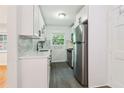Updated kitchen with white cabinets, stainless steel appliances, stylish black faucet, and hardwood floors in adjoining room at 1284 Piedmont Ne Ave # 12, Atlanta, GA 30309