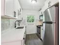 Modern kitchen with white cabinets, stainless steel appliances, a white countertop, and a stylish black kitchen faucet at 1284 Piedmont Ne Ave # 12, Atlanta, GA 30309