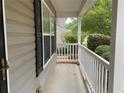 A view of the cozy front porch featuring white pillars and shaded by greenery at 6738 Brookfield Way, Douglasville, GA 30134