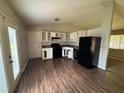 A kitchen featuring white cabinets and dark appliances with modern flooring and a door leading to the outside at 3217 Canterbury Trl, Rex, GA 30273