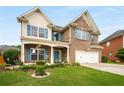 Inviting two-story brick home with a manicured lawn and vibrant blue shutters at 872 Misty View Ct, Lilburn, GA 30047