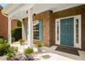Charming covered front porch with vibrant flowers and beautiful brickwork at 872 Misty View Ct, Lilburn, GA 30047