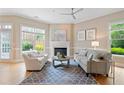 Inviting living room features a fireplace, neutral decor, a ceiling fan, and lots of natural light at 11945 Dancliff Trce, Alpharetta, GA 30009