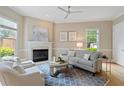 Inviting living room features a fireplace, neutral decor, a ceiling fan, and lots of natural light at 11945 Dancliff Trce, Alpharetta, GA 30009