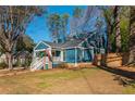 Inviting blue home with dormer windows, a fenced yard and mature trees at 1555 Steele Nw Dr, Atlanta, GA 30309