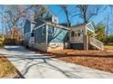 View of a blue home with a stone foundation, and a long driveway at 1555 Steele Nw Dr, Atlanta, GA 30309