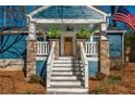 Cozy front porch with stone columns, hanging plants, and a ceiling fan at 1555 Steele Nw Dr, Atlanta, GA 30309