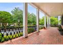 Inviting front porch with brick flooring, stately columns, and wrought iron railings at 3786 Turnberry Ct, Duluth, GA 30096