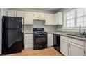 Well-lit kitchen with white cabinets, granite countertops, and modern appliances at 5073 Leland Dr, Stone Mountain, GA 30083
