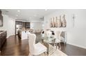 Open concept dining area with stainless steel appliances, dark cabinets, hardwood floors, and modern decor at 7644 Rudder Cir, Fairburn, GA 30213