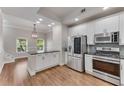 Open-concept kitchen with island, stainless appliances, and stylish lighting at 793 Inman Mews Ne Dr, Atlanta, GA 30307