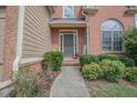 Inviting front entrance with landscaped walkway, decorative plants, and charming covered doorway at 25 Nunnally Pl, Villa Rica, GA 30180