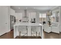 Modern kitchen featuring white cabinets, stainless steel appliances, an island and a breakfast nook at 545 Hanlon Way, Alpharetta, GA 30009